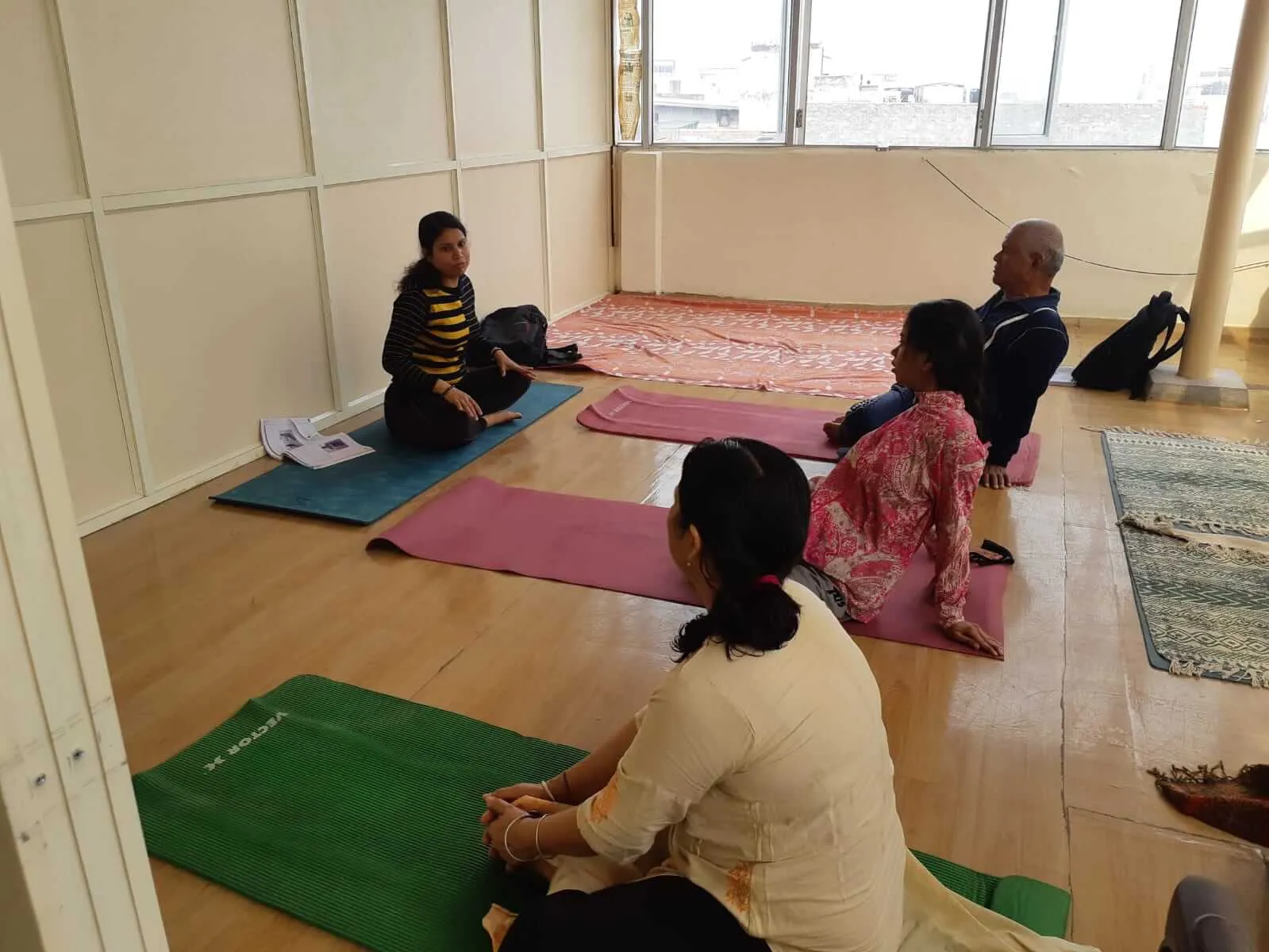 Women stretching on yoga mats during a TPNF session.